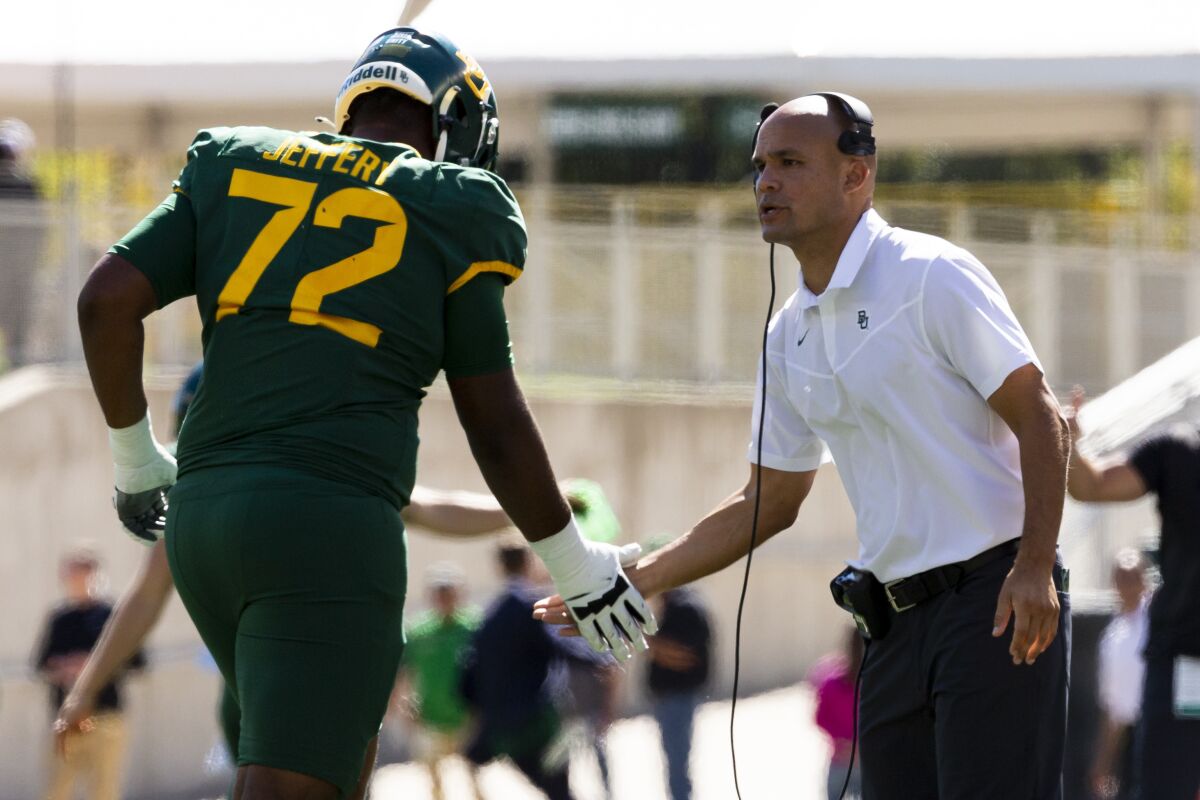 Baylor coach Dave Aranda congratulates offensive lineman Mose Jeffery after a score