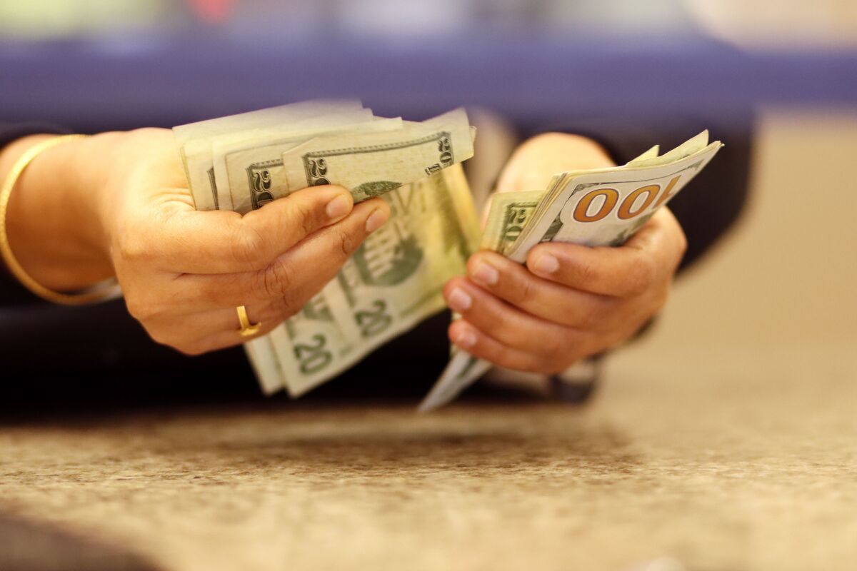 An employee counts money at Mission Federal's Mira Mesa Blvd. West branch last year.