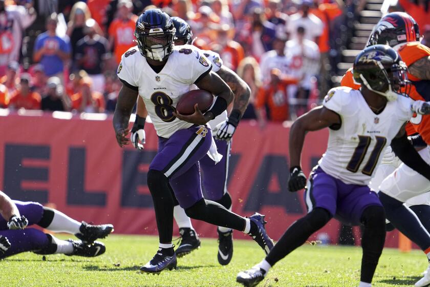Ravens quarterback Lamar Jackson (8) runs the ball at Denver on Oct. 3, 2021.