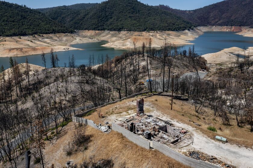 A home destroyed in the 2020 North Complex Fire sits above Lake Oroville on Sunday, May 23, 2021, in Oroville, Calif. At the time of this photo, the reservoir was at 39 percent of capacity and 46 percent of its historical average. California officials say the drought gripping the U.S. West is so severe it could cause one of the state's most important reservoirs to reach historic lows by late August, closing most boat ramps and shutting down a hydroelectric power plant during the peak demand of the hottest part of the summer. (AP Photo/Noah Berger)