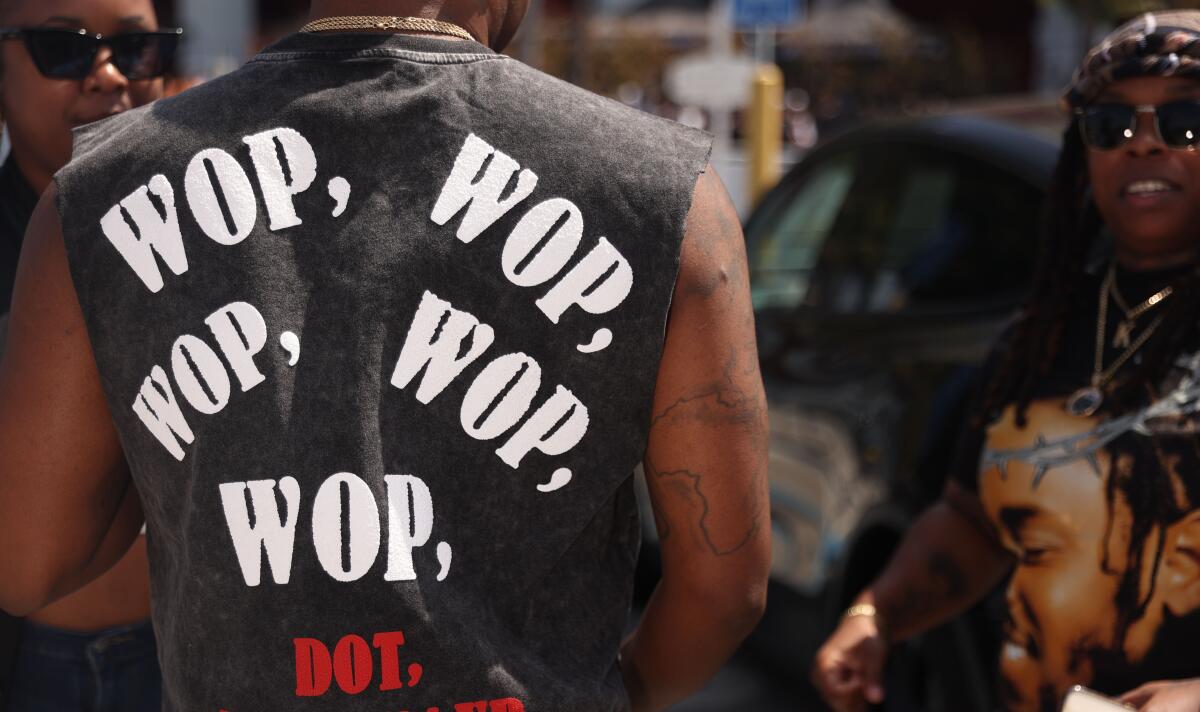 Man in shirt that says "Wop, wop, wop, wop, wop!"