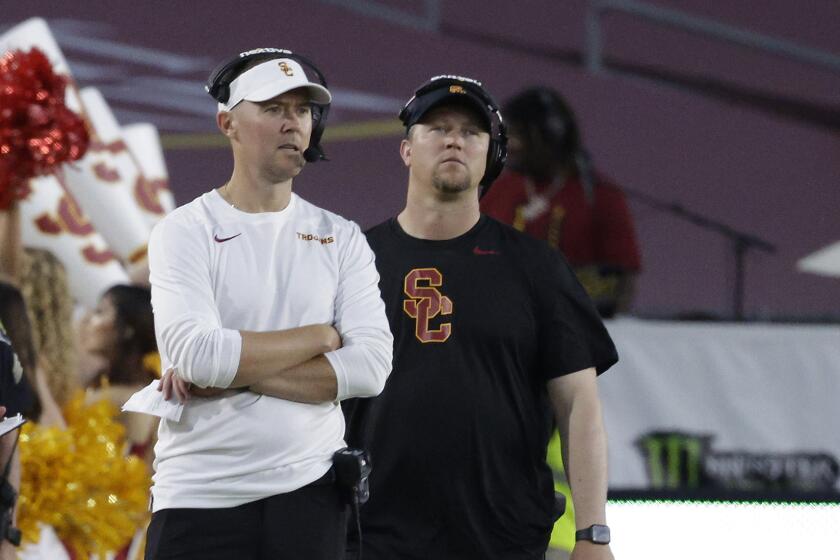 USC coach Lincoln Riley is surrounded by staff on the sideline as he watches his team beat San Jose State 