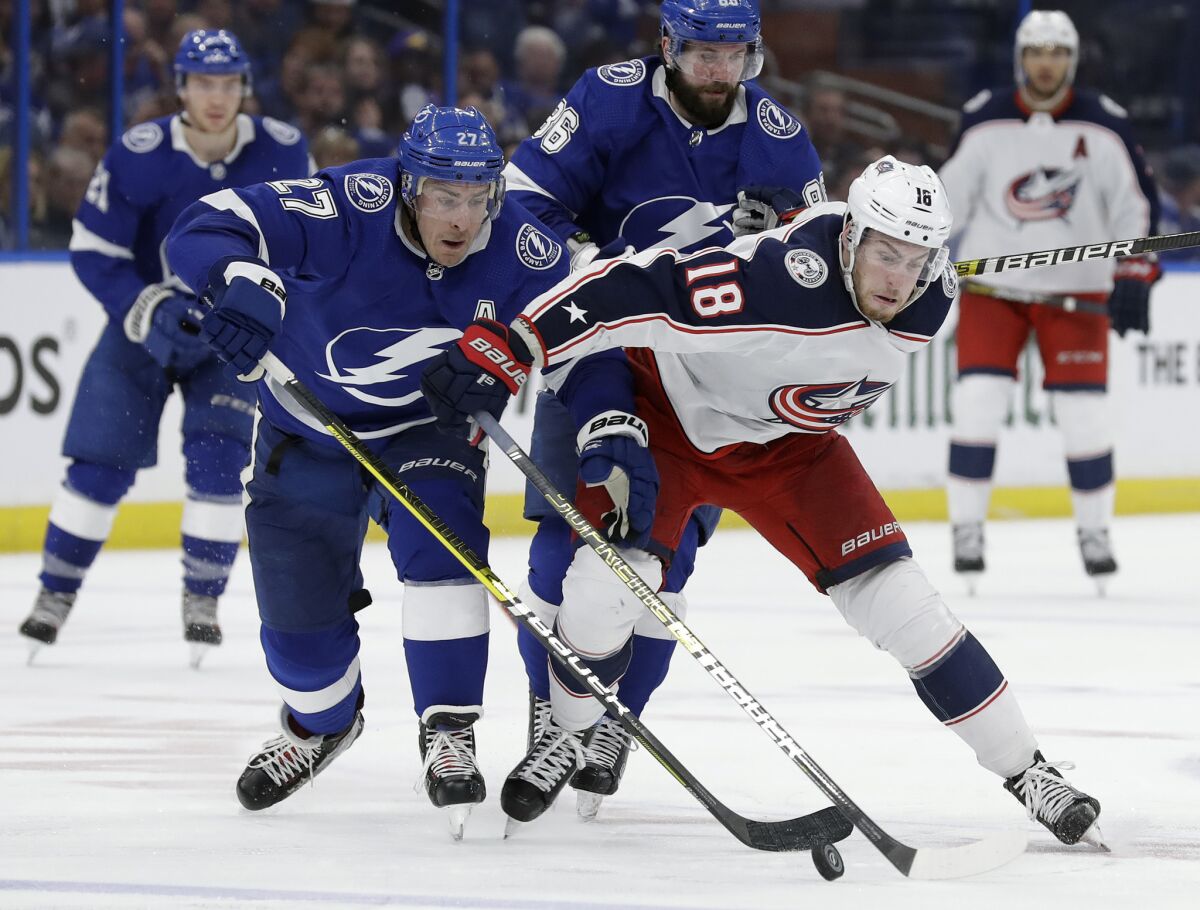 Columbus Blue Jackets center Pierre-Luc Dubois (18) and Tampa Bay Lightning defenseman Ryan McDonagh (27) compete for the puck during the third period of Game 1 of an NHL Eastern Conference first-round hockey playoff series on Wednesday in Tampa, Fla.