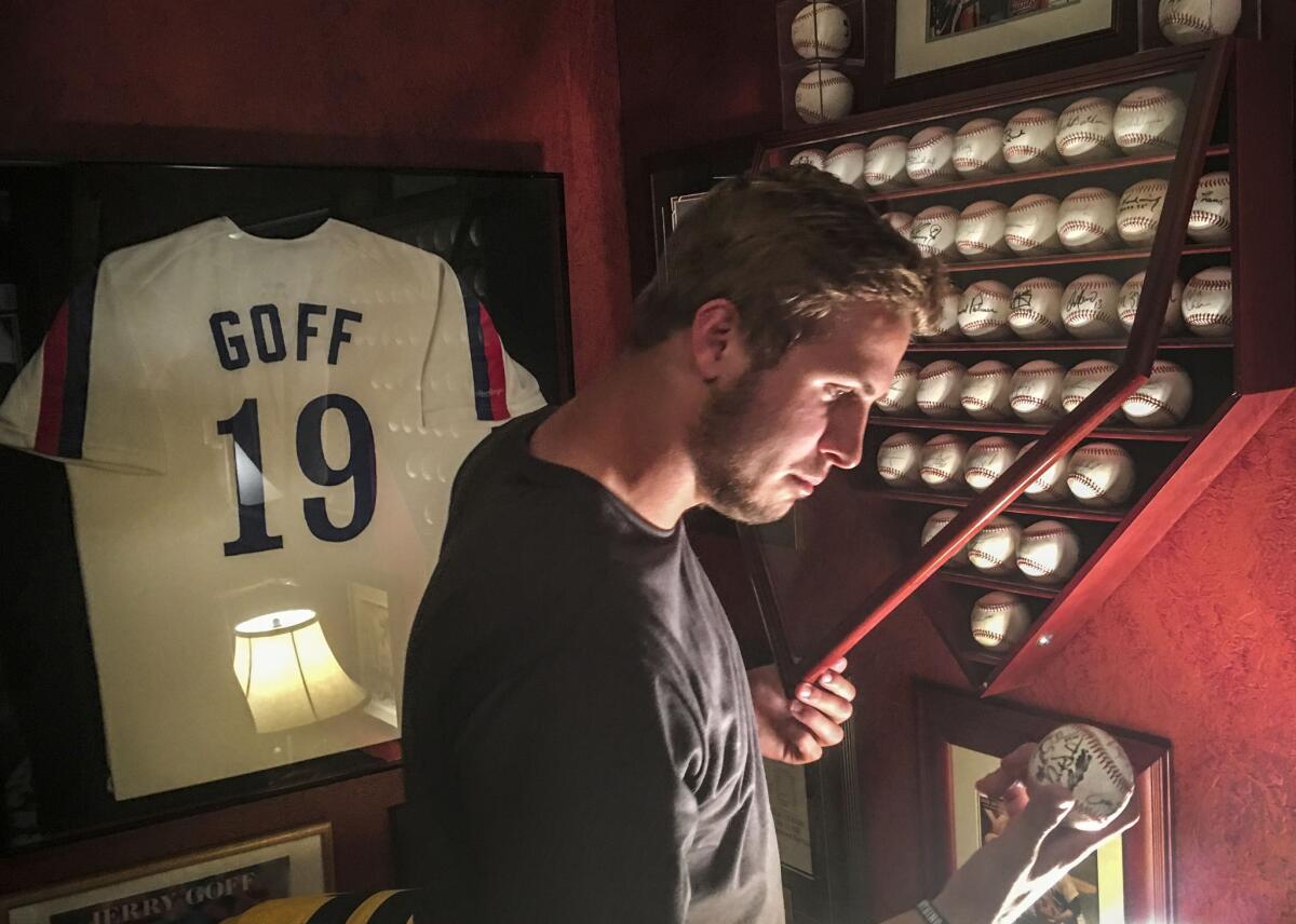 California quarterback Jared Goff examines one of his father's commemorative baseballs in the family's home in Novato, California.