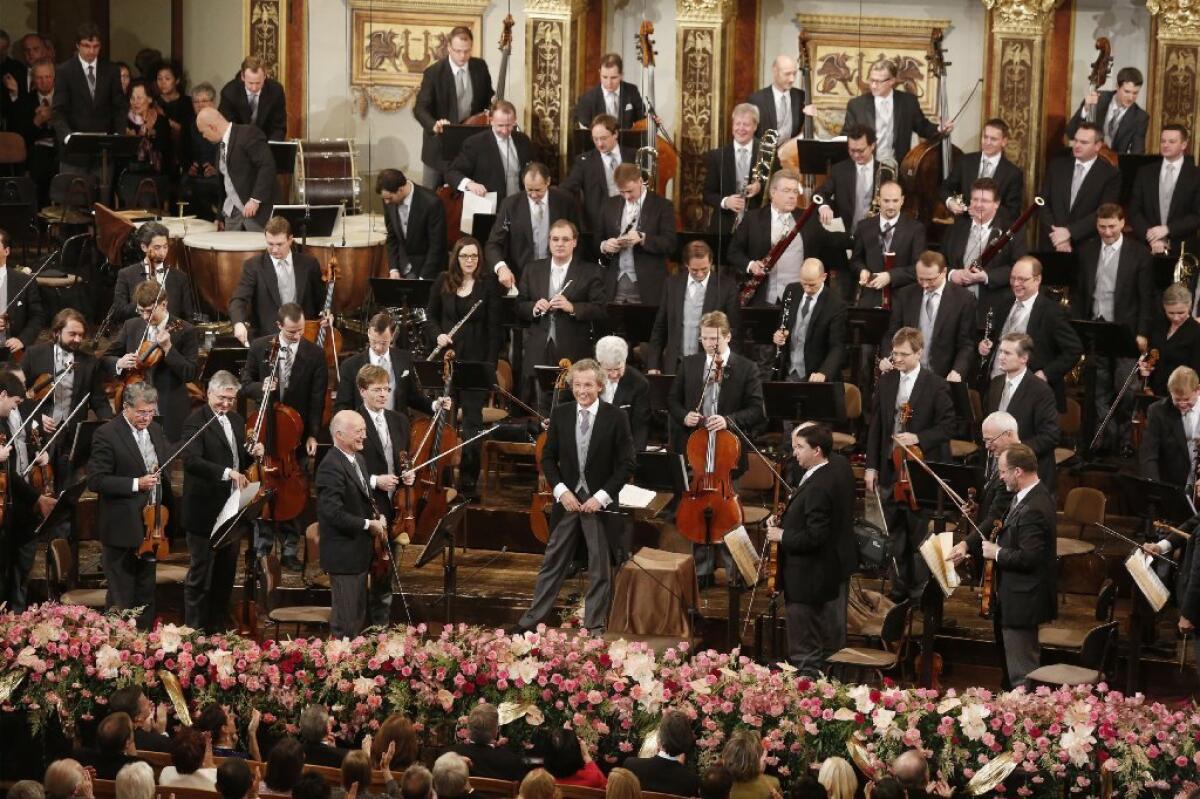 Conductor Franz Welser-Most and members of the Vienna Philharmonic Orchestra after its annual new year's concert in Vienna.