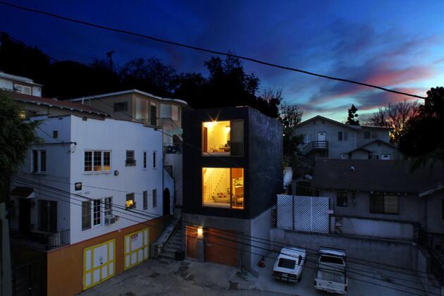 Storey's modern box glows in the evening. The main living area, two bedrooms and one bathroom are built above the garage, in the crook of an L-shaped, one-way street. Storey bought the tiny 1929 house on the lot in 2007, at the height of the real estate boom, for $270,000, nearly 10 times the selling price a decade earlier. He rebuilt from the ground up starting in early 2010; with a construction budget of just $110,000, he had to abandon plans to clad the house in wood once he discovered that fire treatment would be prohibitively expensive. Instead, the exterior is black stucco and inspired by the long but narrow buildings common in urban Japan. Storey dubbed the home Eel's Nest.
