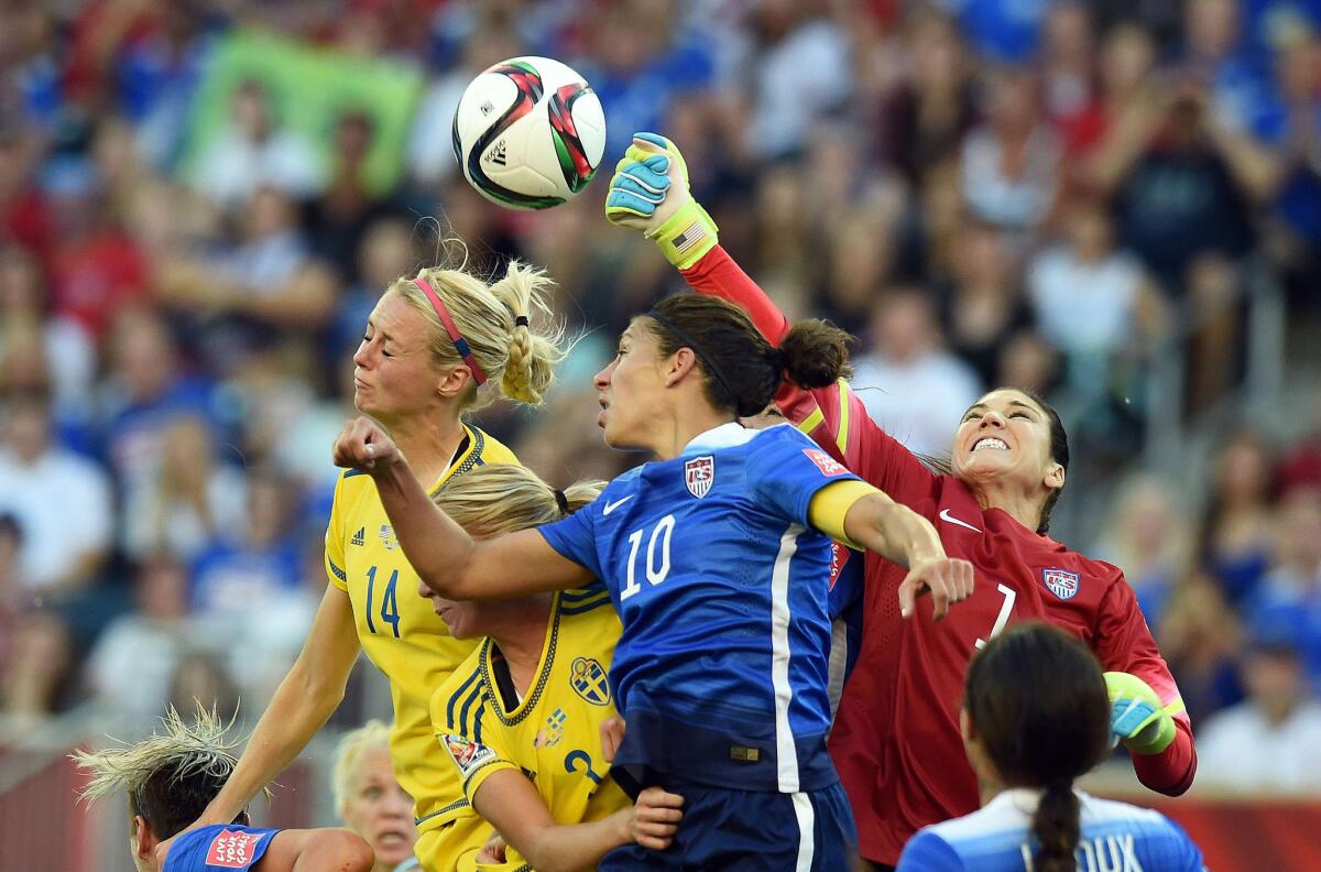U.S. goalkeeper Hope Solo punches away a pass that teammate Carli Lloyd (10) and Sweden defender Amanda Ilestedt attempt to head during their Group D game on Friday in the Women's World Cup.