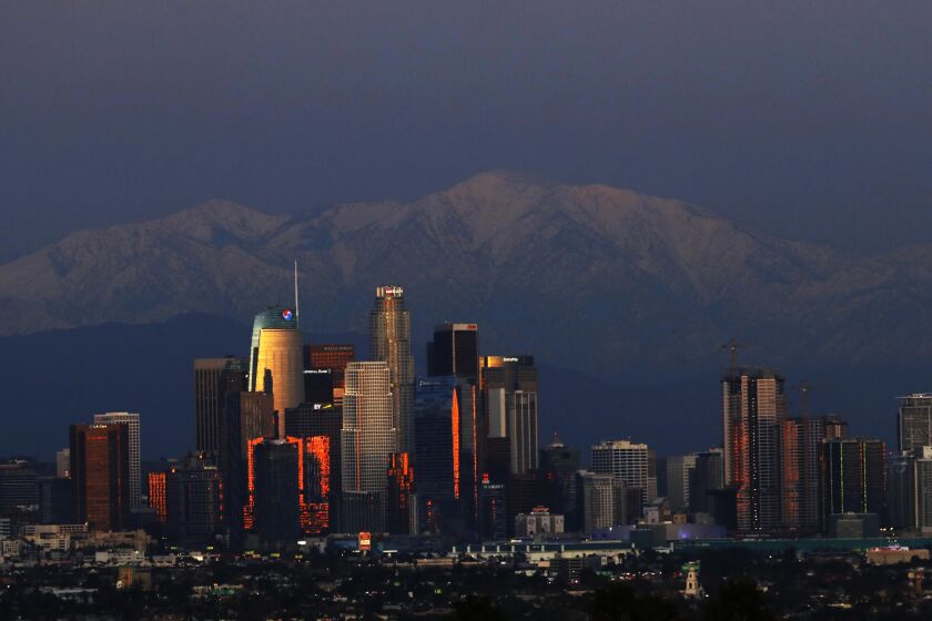 LOS ANGELES, CA - DECEMBER 27, 2019 - Snow covered San Gabriel Mountains provide a wintery backdrop for the downtown Los Angeles skyline on December 27, 2019. Snow is the remnants of two storms that recently passed through the Southland. Another storm is expected to bring more rain to the region on Sunday. (Genaro Molina / Los Angeles Times)