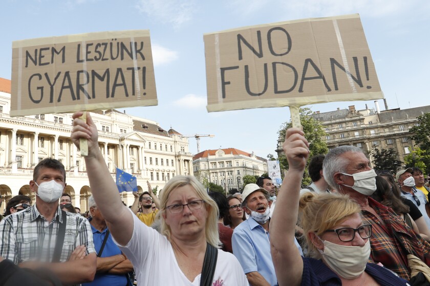 Protesters hold placards reading in Hungarian 'we will not be a colony', left, and 'no Fudan' as they gather in downtown Budapest, Hungary, Saturday, June 5, 2021. Thousands of people gathered opposing the Hungarian government's plan of building a campus for China's Fudan University in Budapest. (AP Photo/Laszlo Balogh)