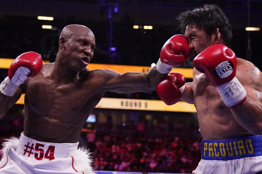 Yordenis Ugas, left, of Cuba, hits Manny Pacquiao, of the Philippines, in a welterweight championship boxing match Saturday, Aug. 21, 2021, in Las Vegas. (AP Photo/John Locher)