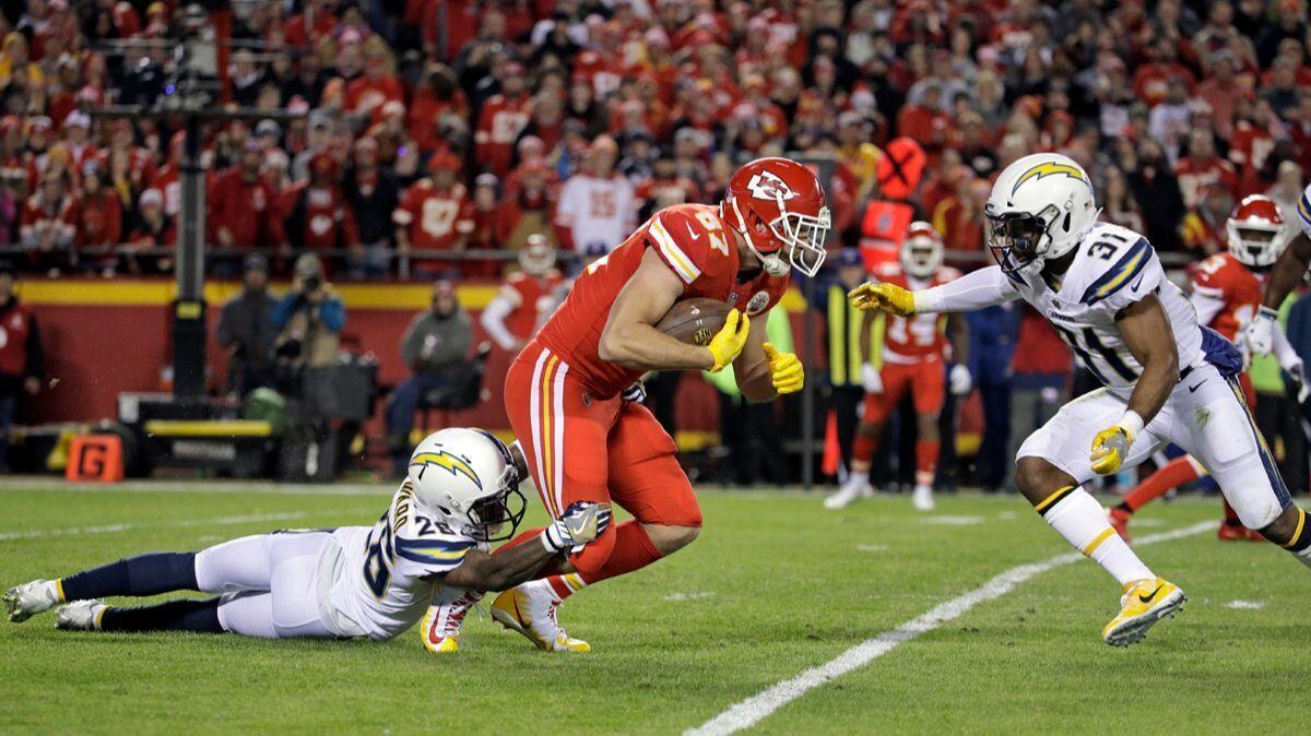 Kansas City Chiefs tight end Travis Kelce is tackled by Chargers cornerback Casey Hayward (26) and safety Adrian Phillips (31) during a Dec. 16 in Kansas City.