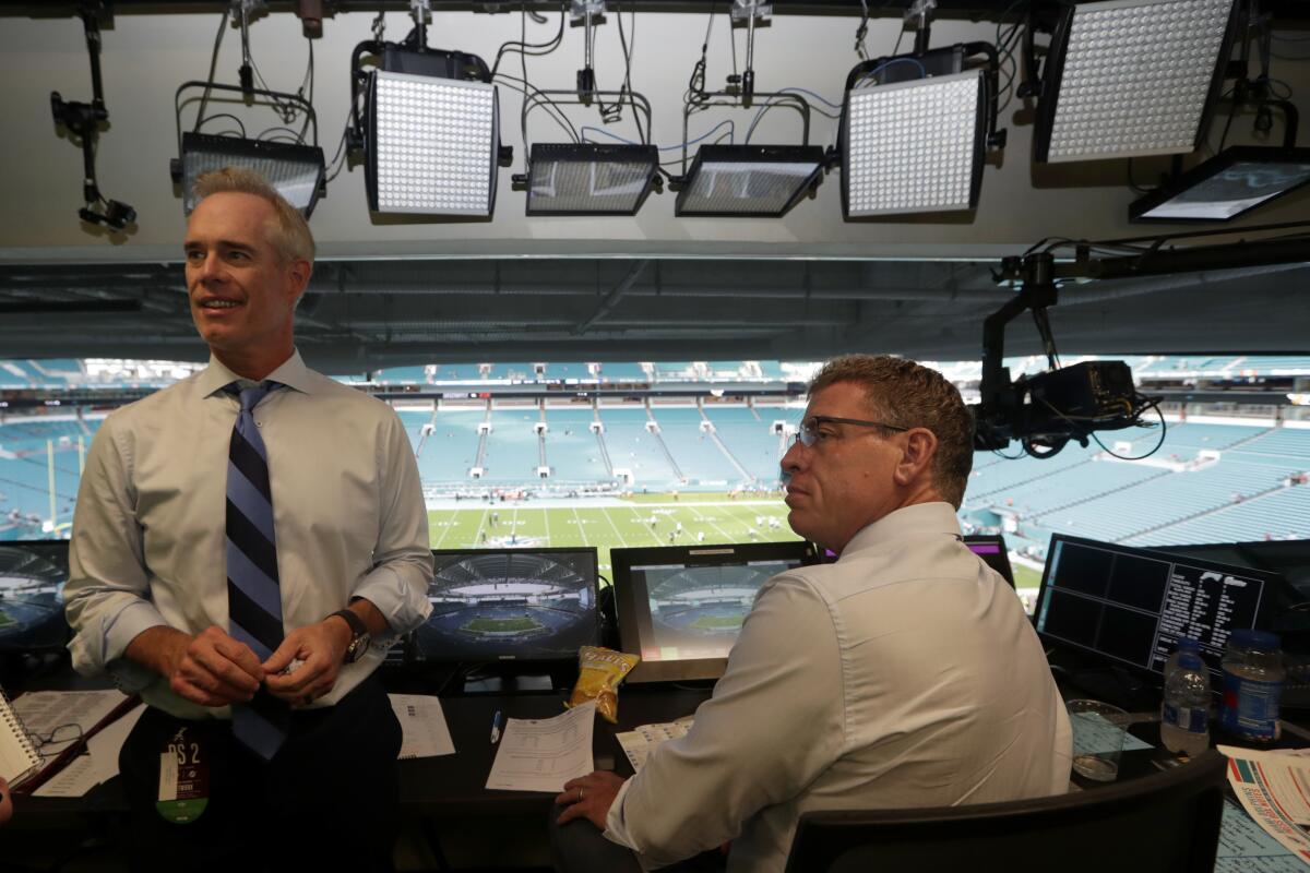Fox Sports play-by-play announcer Joe Buck, left, and analyst Troy Aikman  work in the broadcast booth 