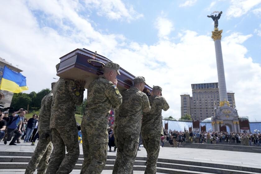CAPTION CORRECTS FAMILY NAME OF SOLDIER Soldiers carry the coffin of activist and soldier Roman Ratushnyi for a memorial service at Maidan square in Kyiv, Ukraine, Saturday, June 18, 2022. Ratushnyi died in a battle near Izyum, where Russian and Ukrainian troops are fighting for control the area. (AP Photo/Natacha Pisarenko)