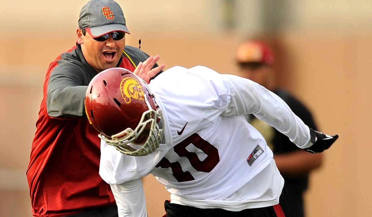 USC Coach Steve Sarkisian chases Hayes Pullard during a break in spring practice last year. Sarkisian will have to replace the senior linebacker.