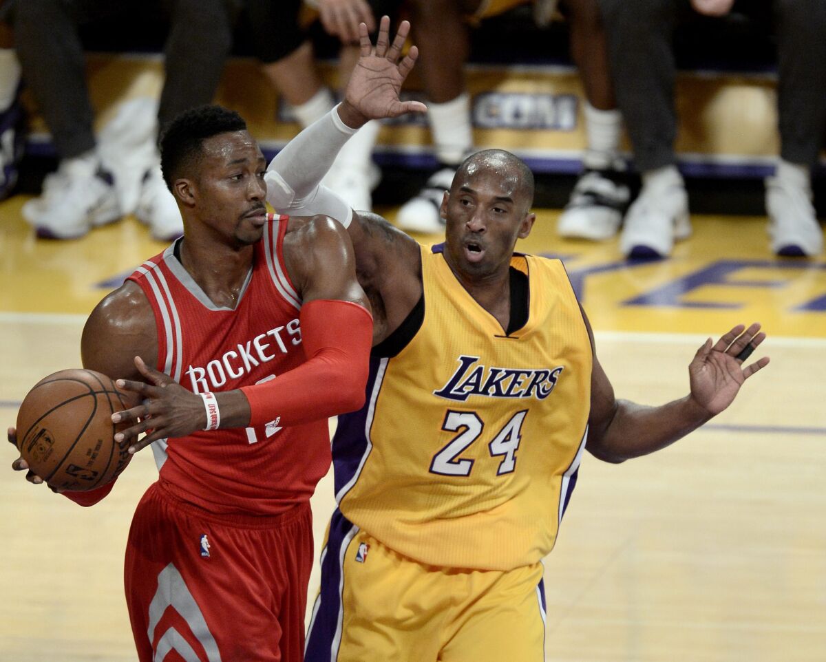 The Houston Rockets' Dwight Howard, left, grabs a rebound away from Los Angeles Lakers' Kobe Bryant in the first half of a game on Thursday, Dec. 17, 2015.
