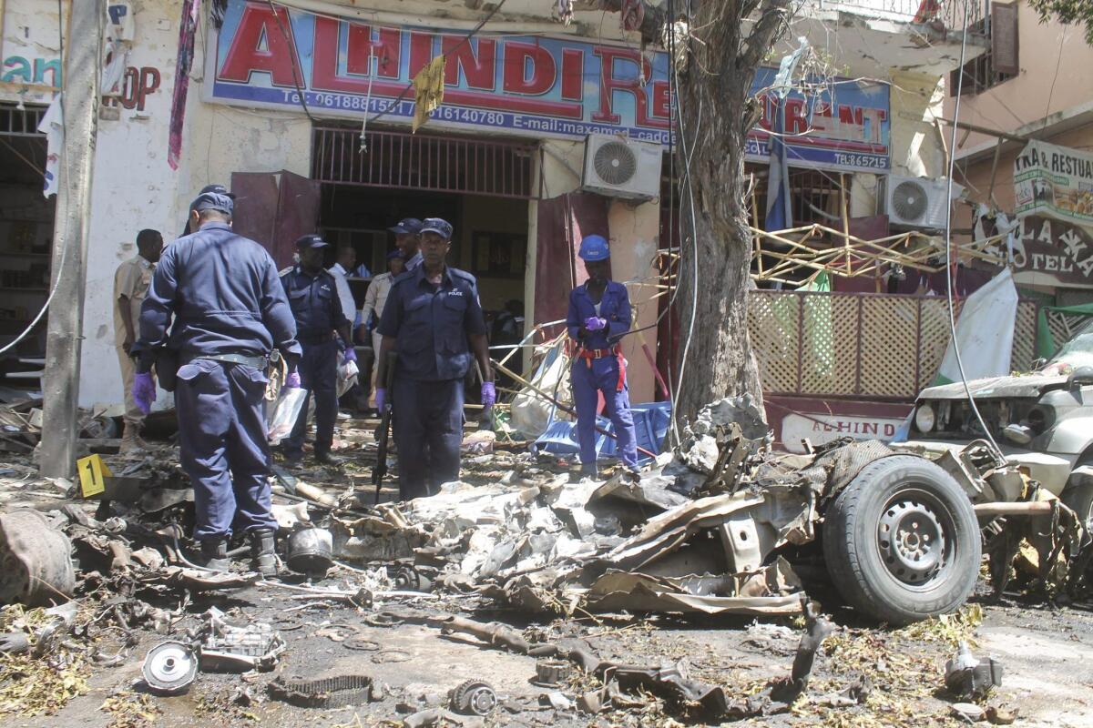 Somali police officers inspect the scene of a car bomb attack in Mogadishu, Somalia, on April 11.