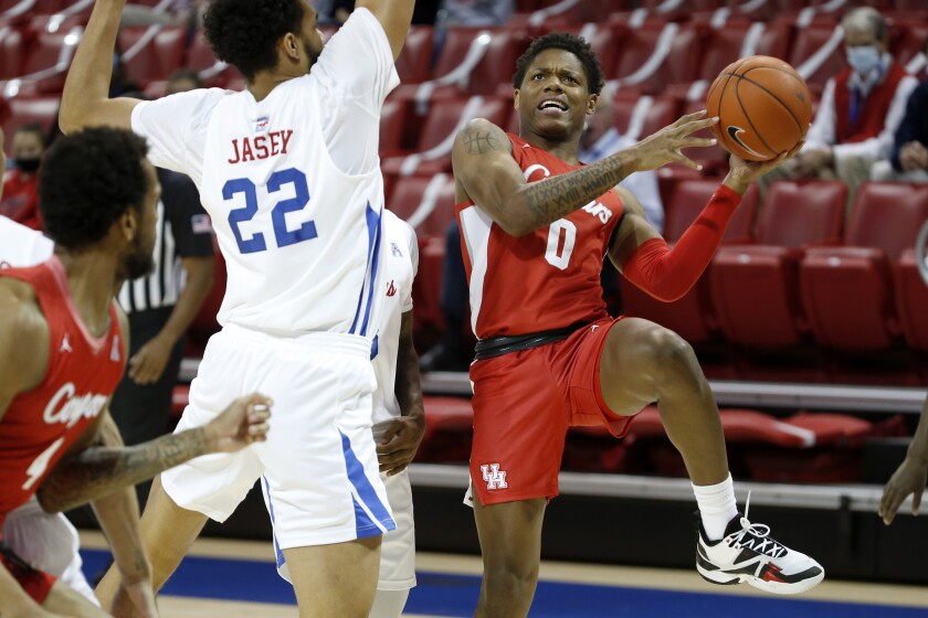 Houston guard Marcus Sasser (0) attempts a shot around the defense of SMU forward Isiah Jasey (22) during the first half of an NCAA college basketball game in Dallas, Sunday, Jan. 3, 2021. (AP Photo/Roger Steinman)