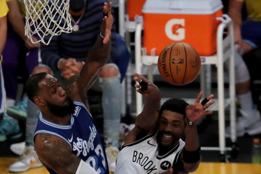 Lakers forward LeBron James defends against Nets guard Kyrie irving