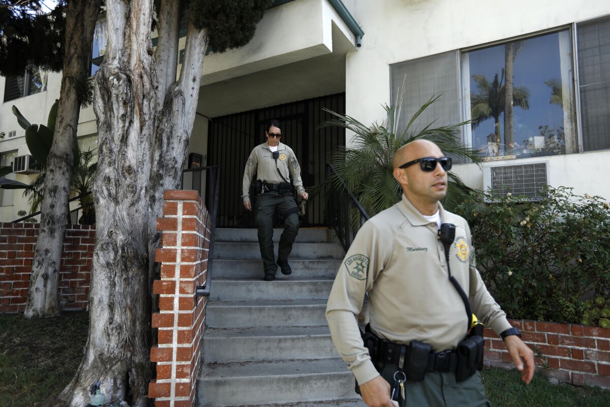 Sheriff's deputies leave the apartment building of Democratic donor Ed Buck