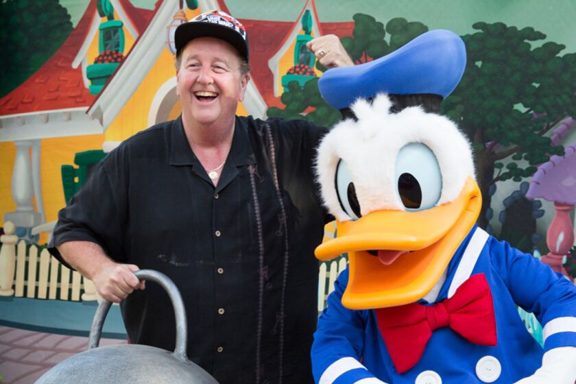 Steve Van Doren, left, the son of Vans co-founder Paul Van Doren, poses with Donald Duck at Disneyland in May during the launch event for a collaboration between the Cypress-based footwear brand and the Anaheim theme park.
