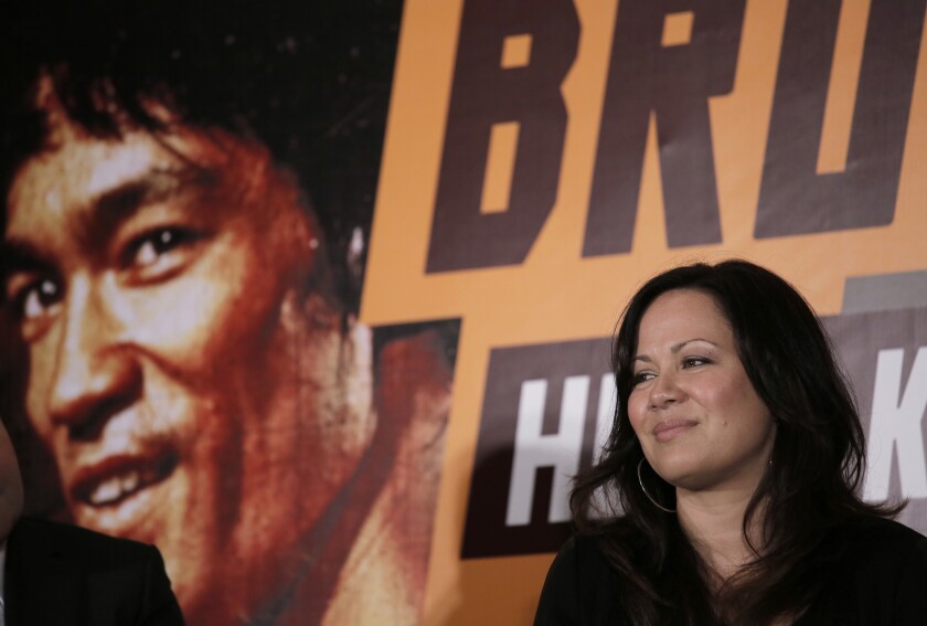 Shannon Lee stands in front of an image of her father Bruce Lee