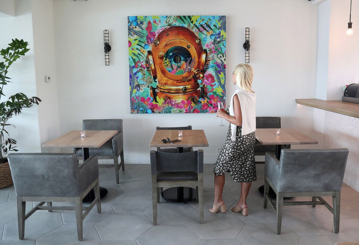 Guest Merry Tungka looks at the artwork in the sushi room of the newly renovated restaurant and lobby at the Hotel Laguna.