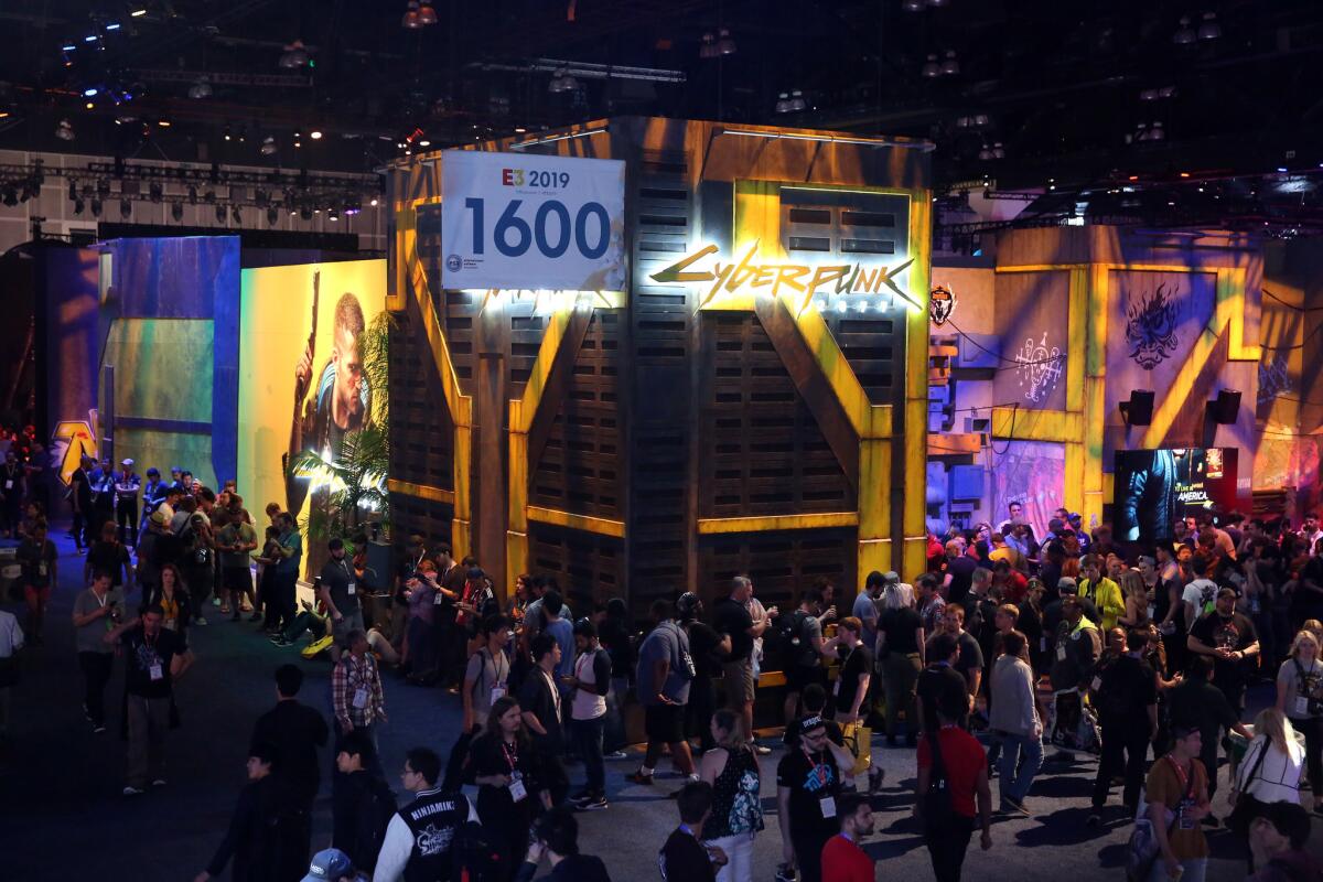 People gather outside of the “Cyberpunk 2077” display while attending the Electronic Entertainment Expo (E3).