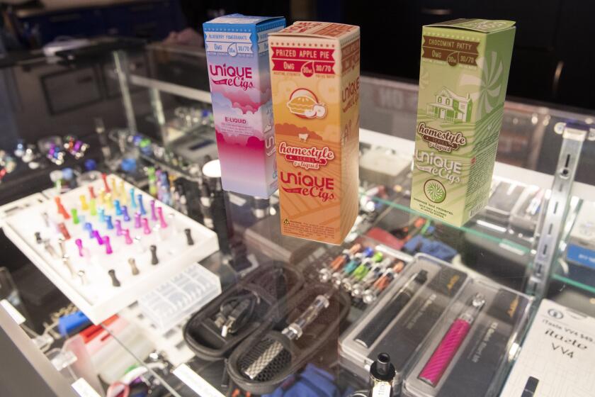 This Jan. 2, 2020, file photo shows flavored vaping liquids and devices on display at the VapeNY.com store in New York. New York lawmakers could ban flavored tobacco products including vape pens and menthol cigarettes amid growing concern over the tobacco industry's use of flavorings to attract young people and African-Americans. A spokesman said Monday, Jan. 13 that the Democratic Senate Majority plans to pass a ban on the sale of flavored e-cigarettes and prohibition on smokeless flavored tobacco products as soon as the following week. (AP Photo/Mary Altaffer, File)