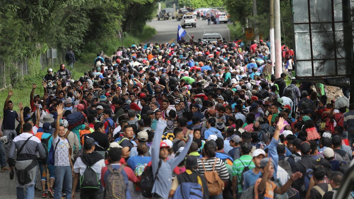 Some 1,500 Honduran immigrants walk north in a migrant caravan on Tuesday near Esquipulas, Guatemala.