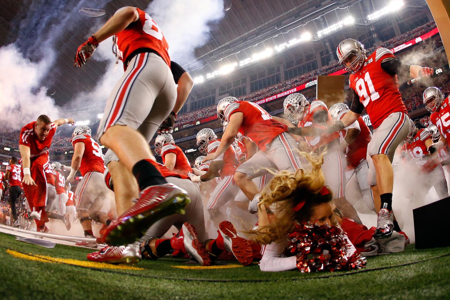 Ohio State players try to avoid running over cheerleader Ally Nelson, who fell in front of them before the College Football Playoff national championship game Monday night at AT&T Stadium.