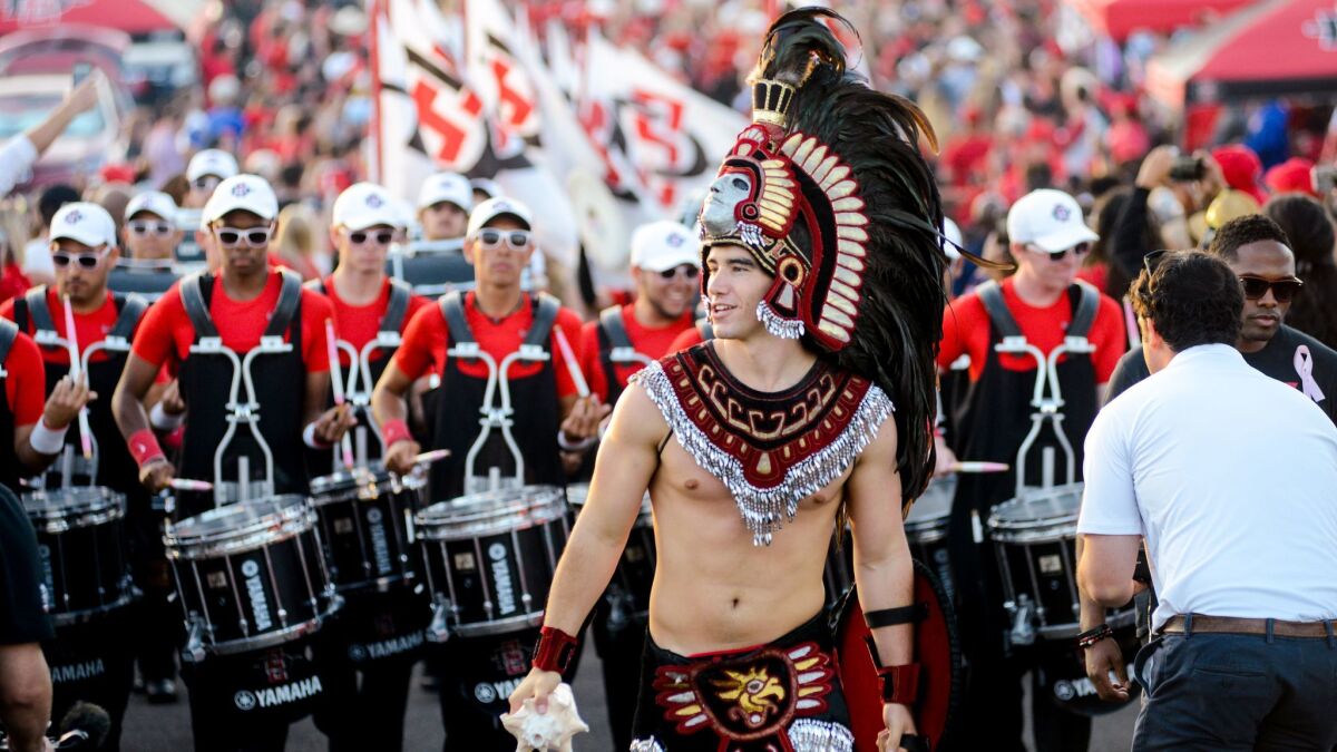 San Diego State's Aztec Warrior leads the band and football team during the Warrior Walk through the alumni section of the SDCCU Stadium parking lot before a football game last fall.