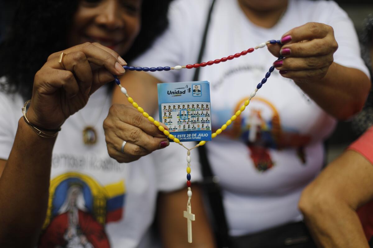 Partidarios de la oposición sostienen un rosario con un volante que muestra al candidato presidencial 