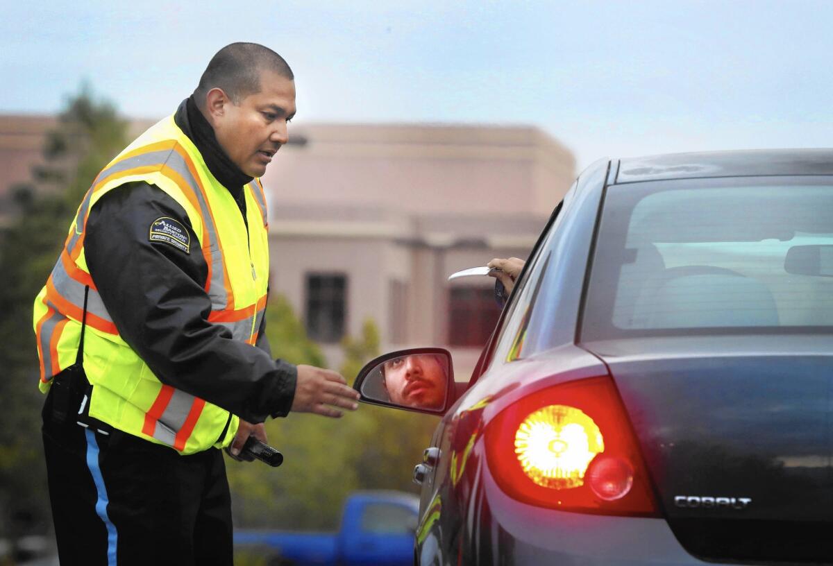 A security officer checks ID badges as employees return to the Inland Regional Center in San Bernardino for the first time since the terror attacks Dec. 2.