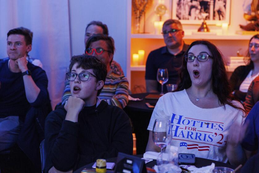 Simon Sutton, 14, and his stepmom Summer Stagg react during a presidential debate between Democratic presidential nominee Vice President Kamala Harris and Republican presidential nominee former President Donald Trump at a watch party hosted by the Alice B. Toklas LGBTQ Democratic Club at the Academy on Tuesday, Sept. 10, 2024, in San Francisco. (AP Photo/Juliana Yamada)