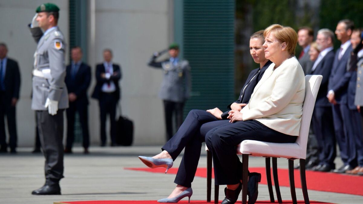 German Chancellor Angela Merkel, right, and Danish Prime Minister Mette Frederiksen sit as they listen to the national anthems during a welcoming ceremony with military honors on July 11, 2019, in the courtyard of the Chancellery in Berlin.