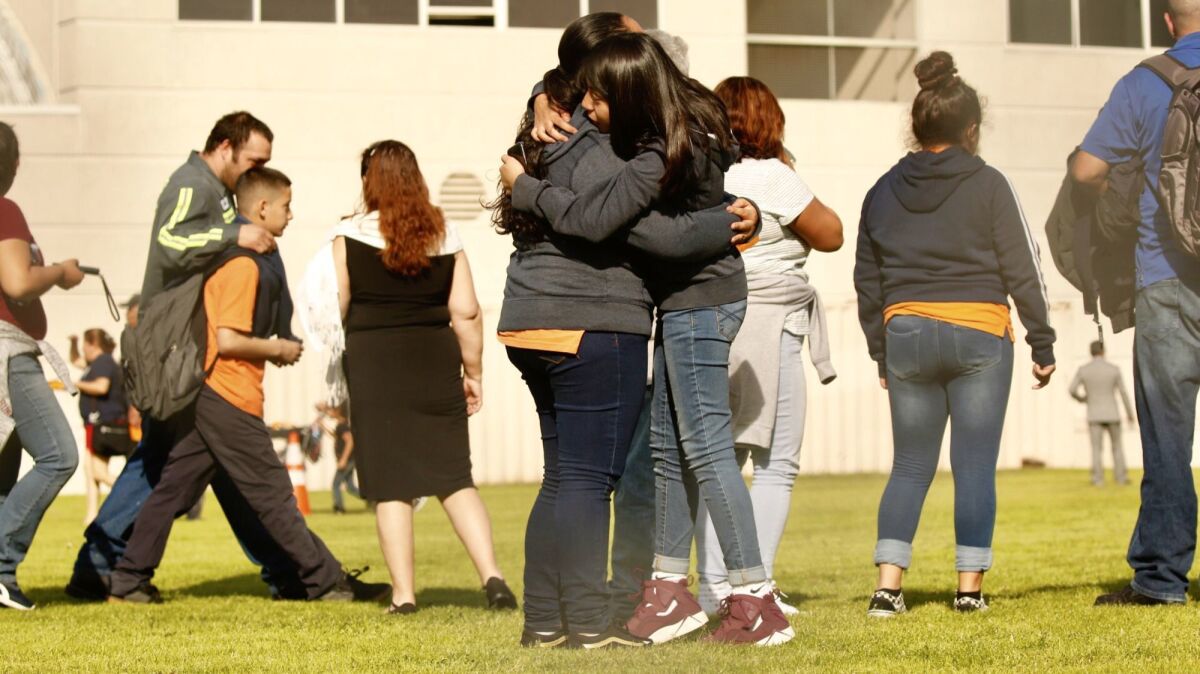 Students and families reunite after a shooting at Sal Castro Middle School in Westlake on Thursday. Two 15-year-olds were wounded by gunfire. A 12-year-old girl is in custody.