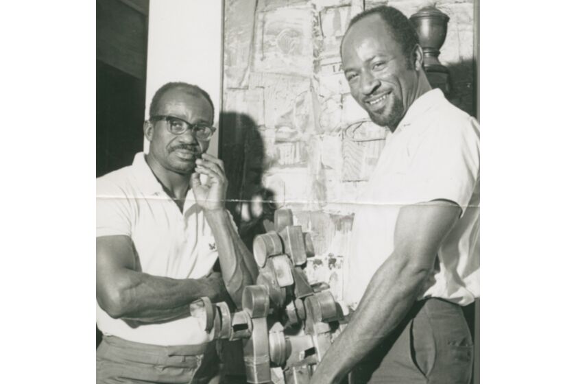 Artist Noah Purifoy, left, with Judson Powell, photographed at the Watts Towers Art Center in 1966. That same year, the pair organized a show inspired by the uprising that would go on to influence a generation of artists.