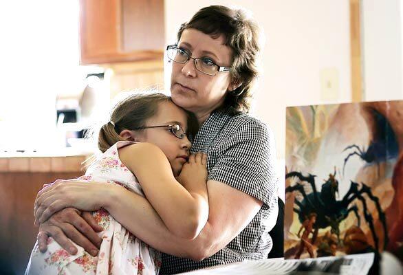 Leslie Udvardi snuggles with her daughter, Esther, as the family plays board games in July 2007. Esther and her three brothers were taken from Leslie and her husband, Kirk, after she was accused of having Munchausen syndrome by proxy in December 2005.