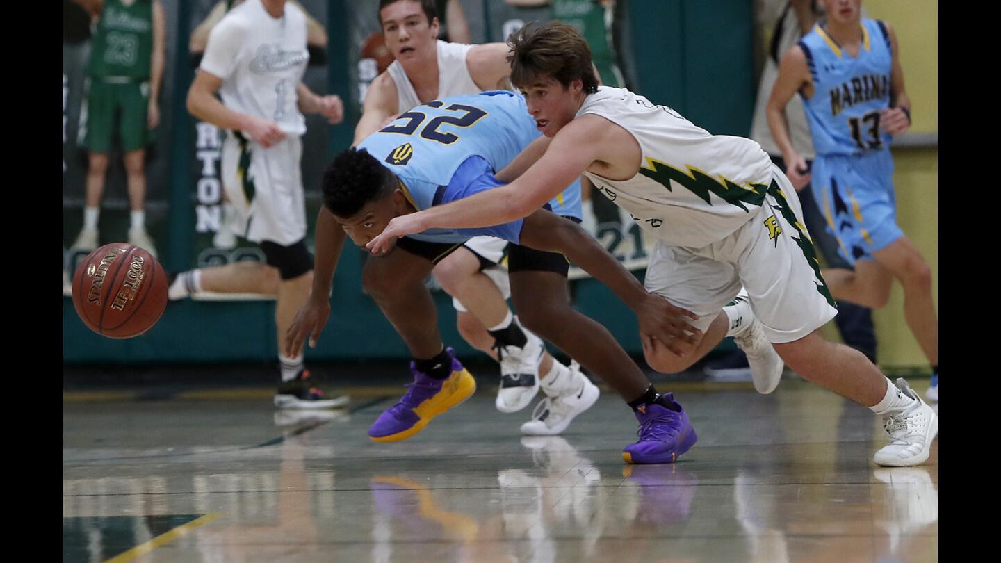 Edison High's Jack Horton, right, steals the ball from Marina's Jakob Alamudun, center, during the first half in a Sunset Conference crossover game on Friday, January 4, 2019.