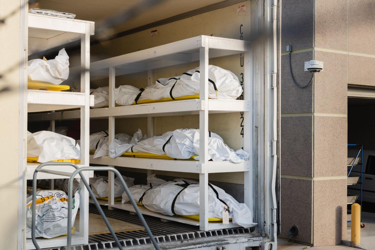 Bodies wrapped in plastic are stacked inside a mobile morgue set up by the medical examiner's office in El Paso on Friday.