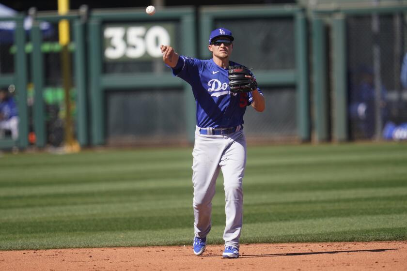 Los Angeles Dodgers shortstop Corey Seager (5) throws to first during a spring training baseball game against the Kansas City Royals, Friday, March 5, 2021, in Surprise, Ariz. (AP Photo/Sue Ogrocki)