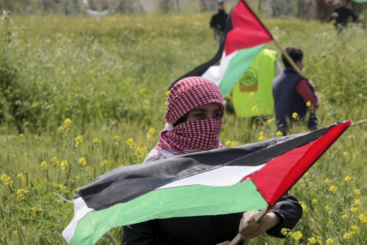 Palestinians wave flags during a rally.