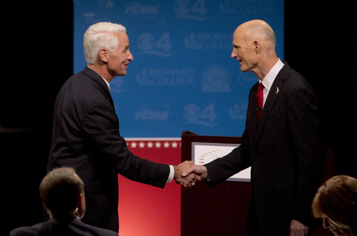Democratic challenger and former Republican Gov. Charlie Crist, left, and Florida Republican Gov. Rick Scott shake hands after participating in a debate on Oct. 15.