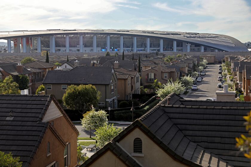 INGLEWOOD, CA - FEBRUARY 08: SoFi Stadium is seen in the background with the Renaissance housing community in the forground on Tuesday, Feb. 8, 2022 in Inglewood, CA. SoFi Stadium and other development has driven up home prices in the City of Inglewood. (Gary Coronado / Los Angeles Times)