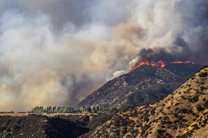 CHERRY VALLEY, CA - AUGUST 1, 2020: Flames shoot up along a ridge above a home as the Apple fire burns out of control during the coronavirus pandemic on August 1, 2020 in Cherry Valley, California. (Gina Ferazzi / Los Angeles Times)