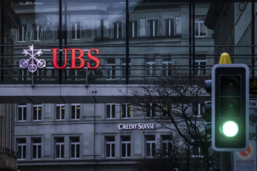 FILE - A traffic light signals green in front of the logos of the Swiss banks Credit Suisse and UBS in Zurich, Switzerland, on March 19, 2023. Analysts say the UBS takeover of embattled rival Credit Suisse has shaken Switzerland’s self-image and dented its reputation as a global financial center. They warn that the country’s prosperity could grow too dependent on a single banking behemoth. (Michael Buholzer/Keystone via AP, File)