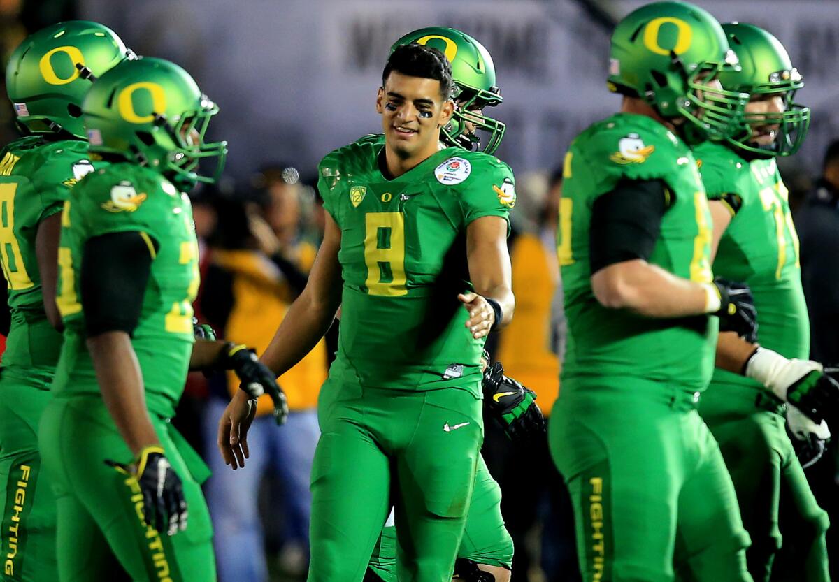 Quarterback Marcus Mariota celebrates with Oregon teammates as they finish off a 59-20 victory over Florida State.