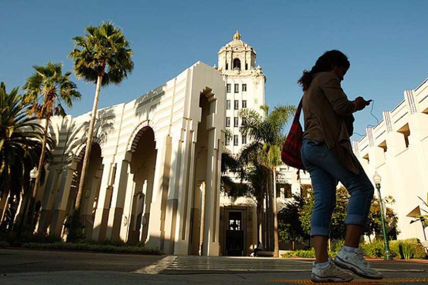 A pedestrian walks near Beverly Hills City Hall. City officials are warning residents to be on guard for a phone scam in which the caller identifies himself as a city official and asks to inspect their property for earthquake damage.