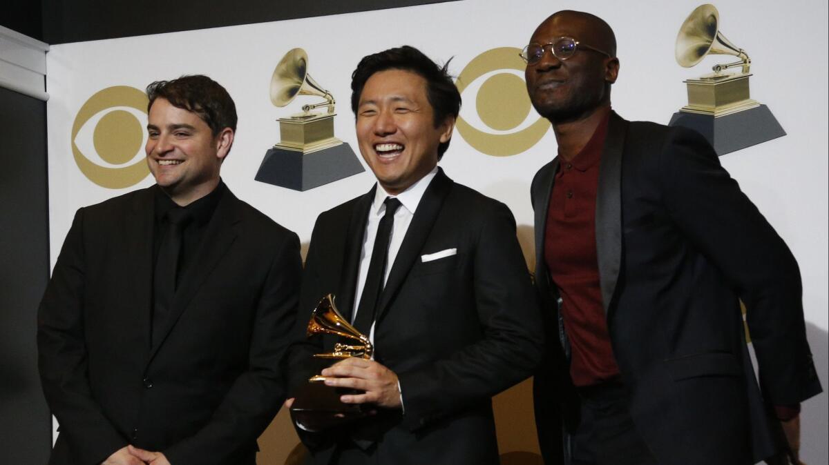 Director Hiro Murai, center, holds the Grammy for best music video for "This Is America" backstage at the Grammys. Neither choreographer Sherrie Silver nor artist Donald Glover attended the Grammys.