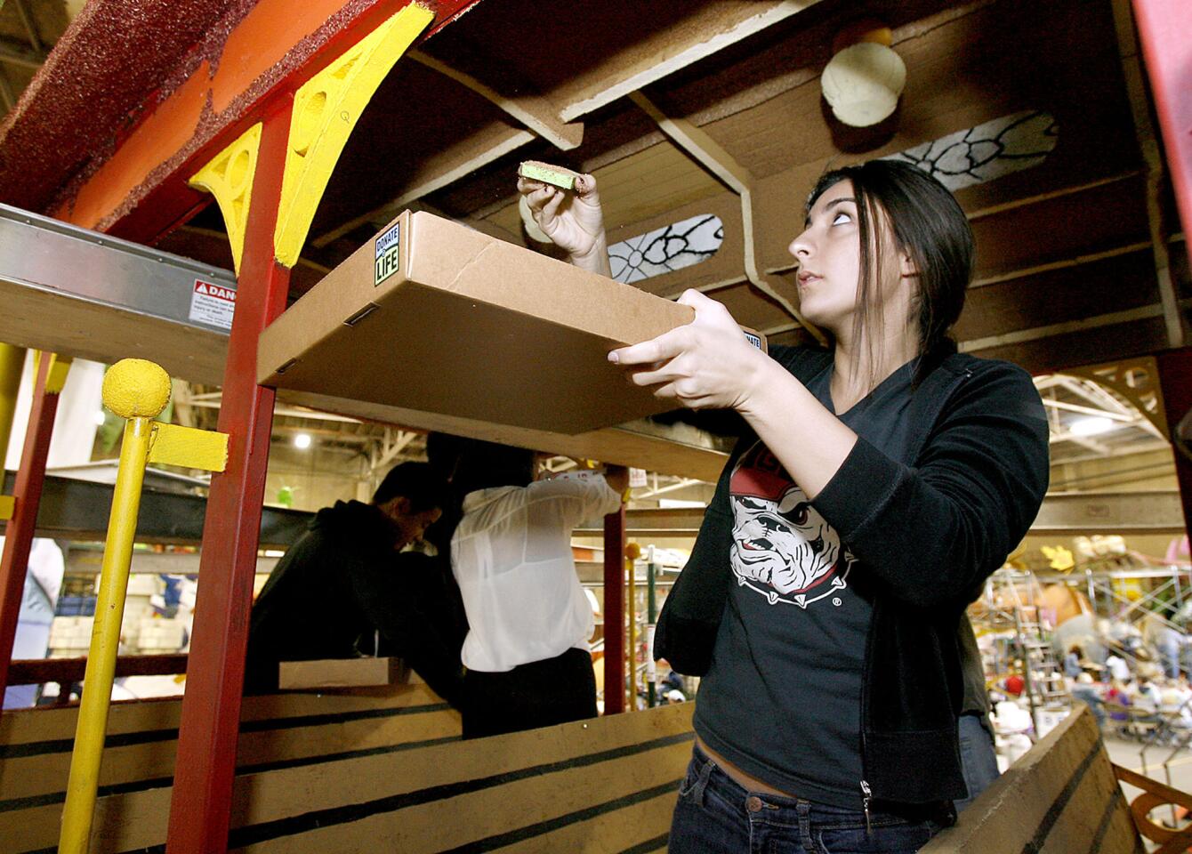 Petra Beglarian, 16 and a junior at Clark Magnet High School in La Crescenta, helps decorate the inside of a trolley replica on the city of Glendale float, at Phoenix Decorating Company in Pasadena on Saturday, December 22, 2012.